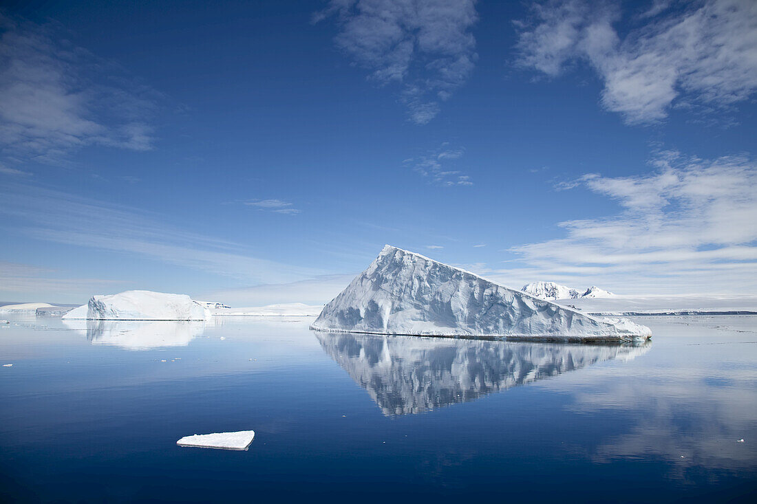 An iceberg reflected in still polar waters.