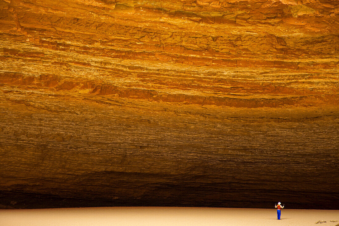 Person dwarfed by massive Redwall Cavern on the Colorado River.