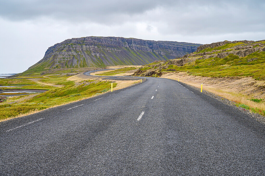 Paved road in the fjord landscape of Vestfjardarvegur trail in summer; Vestfjardarvegur, Westfjords, Iceland