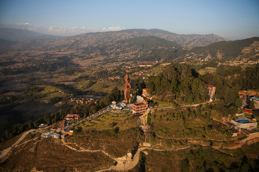 Eine Hindu-Statue auf einem Hügel überblickt die Landschaft in Nepal.