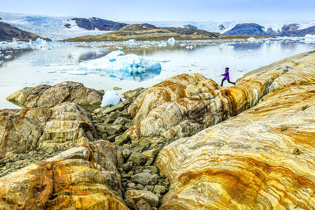 A hiker on metamorphic rocks in Semerlik Fjord.