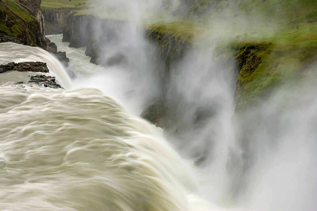 Mist rises at Gullfoss Waterfall, fed by melting glaciers.