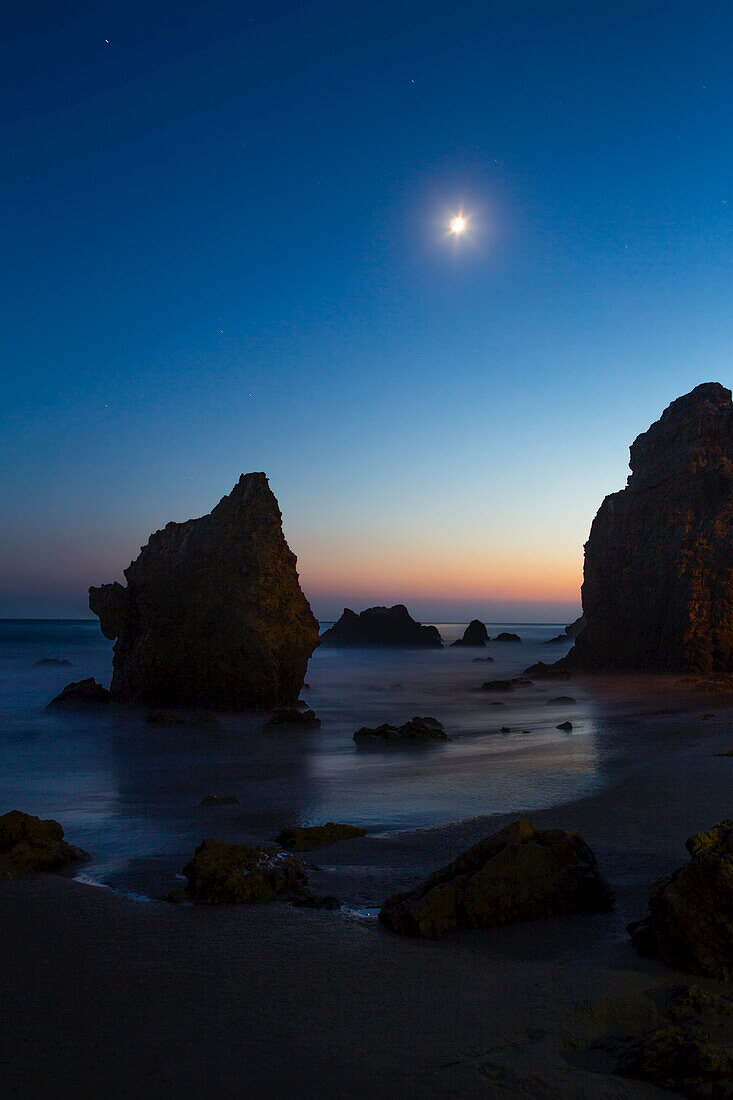 Der Mond über den Felsformationen entlang des El Matador State Beach bei Nacht; Malibu, Kalifornien, Vereinigte Staaten von Amerika