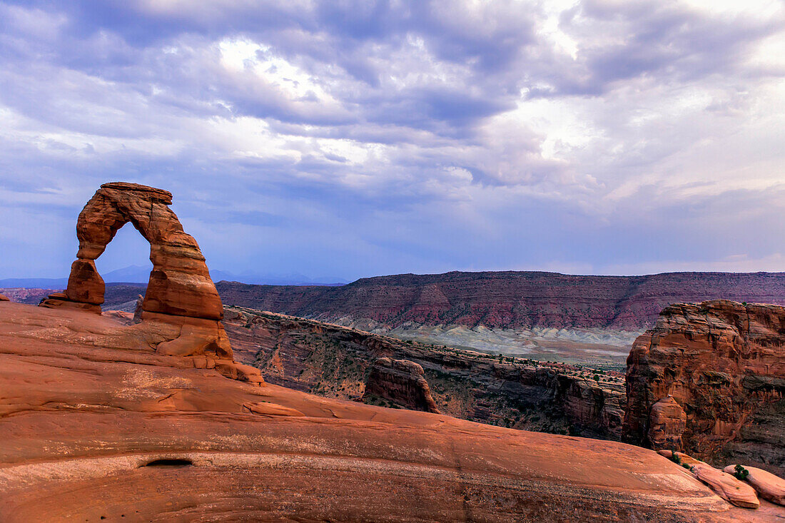 Delicate Arch Felsformation mit bewölktem Himmel in der Nähe von Moab im Arches National Park; Moab, Grand County, Utah, Vereinigte Staaten von Amerika