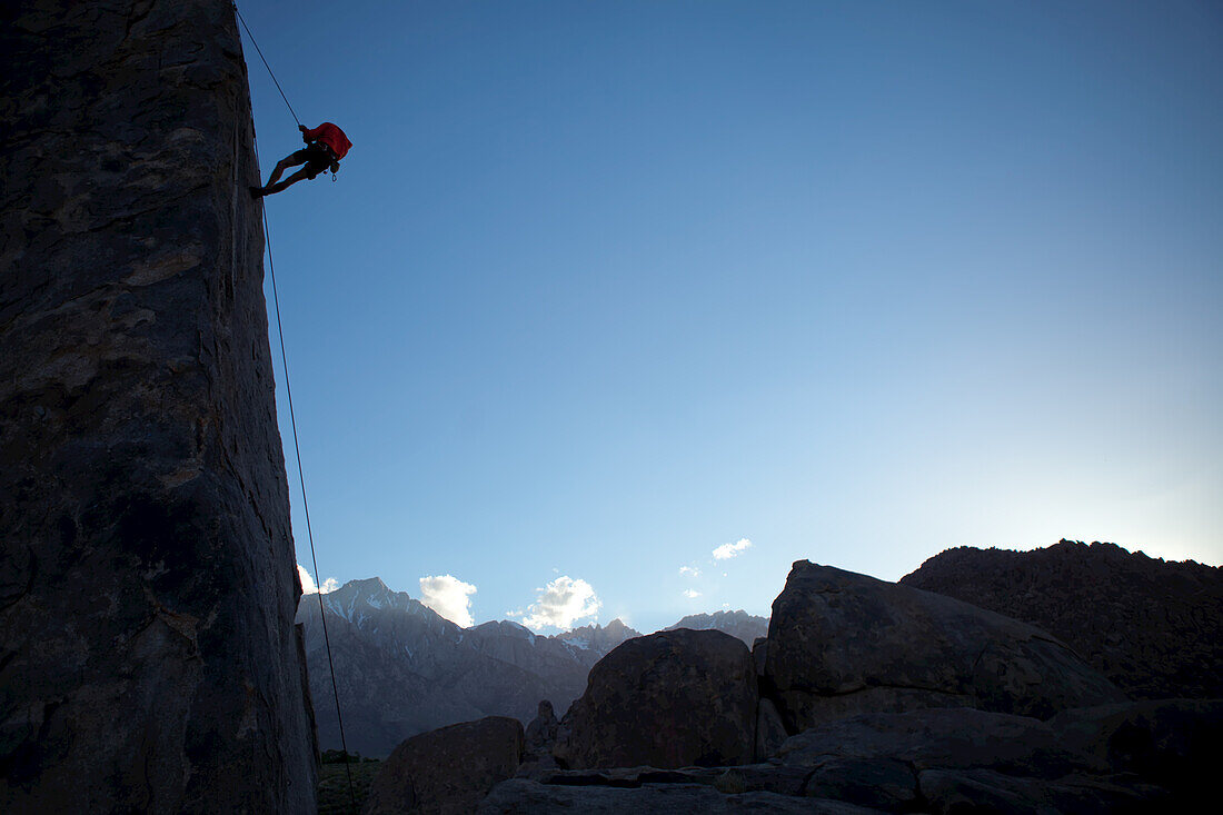 A climber on the 'Sharks Fin' formation; Mt. Whitney in the background.