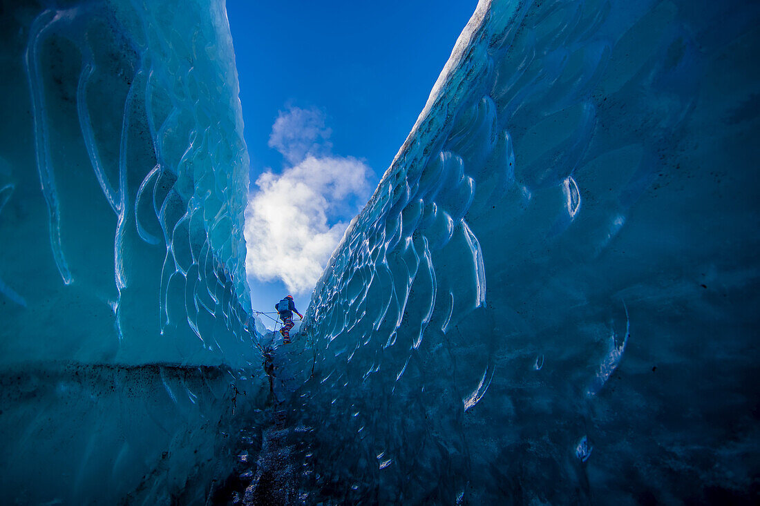 A woman walks through a crevasse in the Vatnajokull glacier.