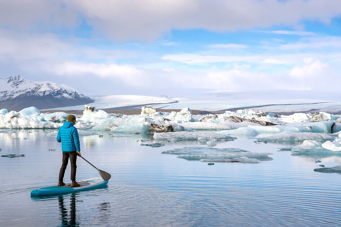 Ein Mann paddelt auf der Jokulsarlon Gletscherlagune.