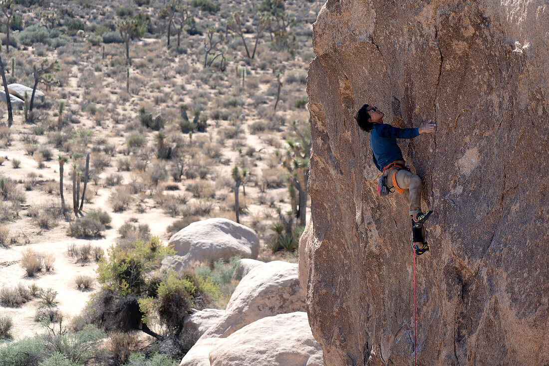 A rock climber working his way up a technical granite face.