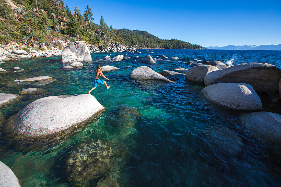 A man jumping into Lake Tahoe near Bonzai Rock.