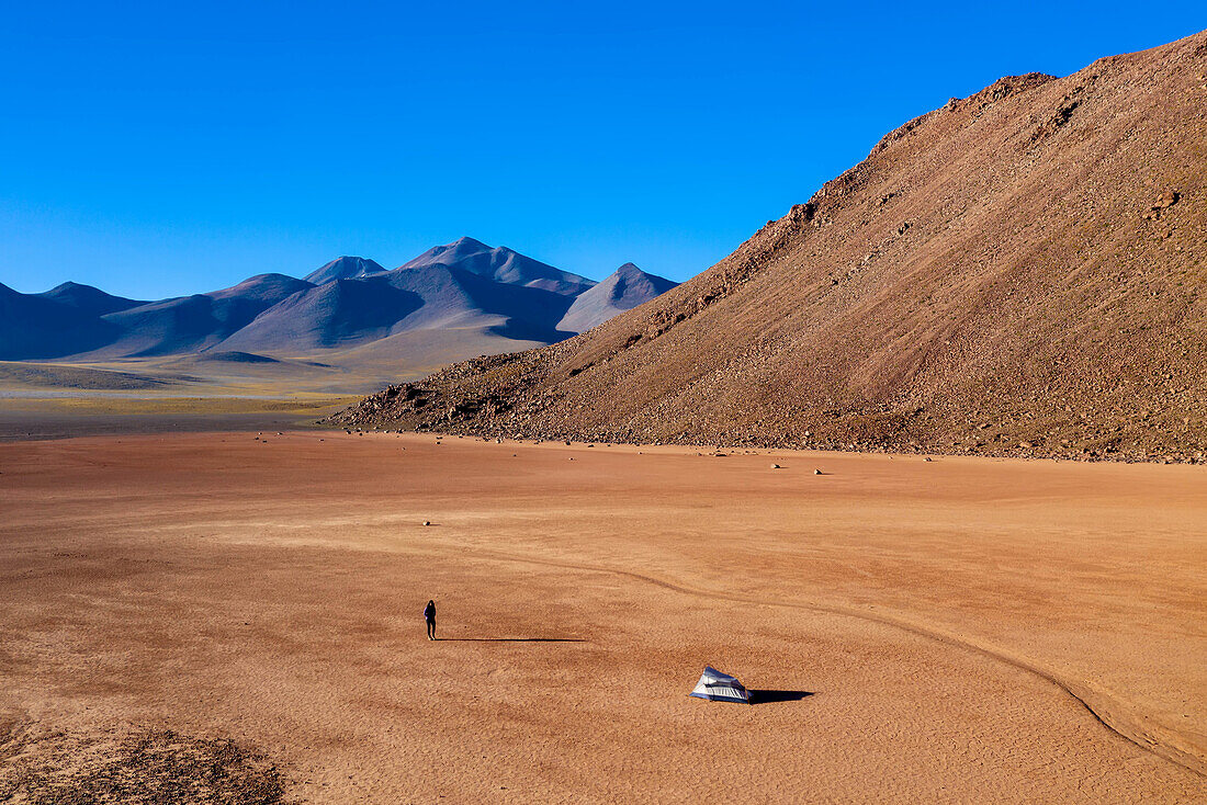 Eine Frau geht zurück zu ihrem Zelt in einem trockenen Seebett in 15.000 Fuß Höhe in der Atacama-Wüste.
