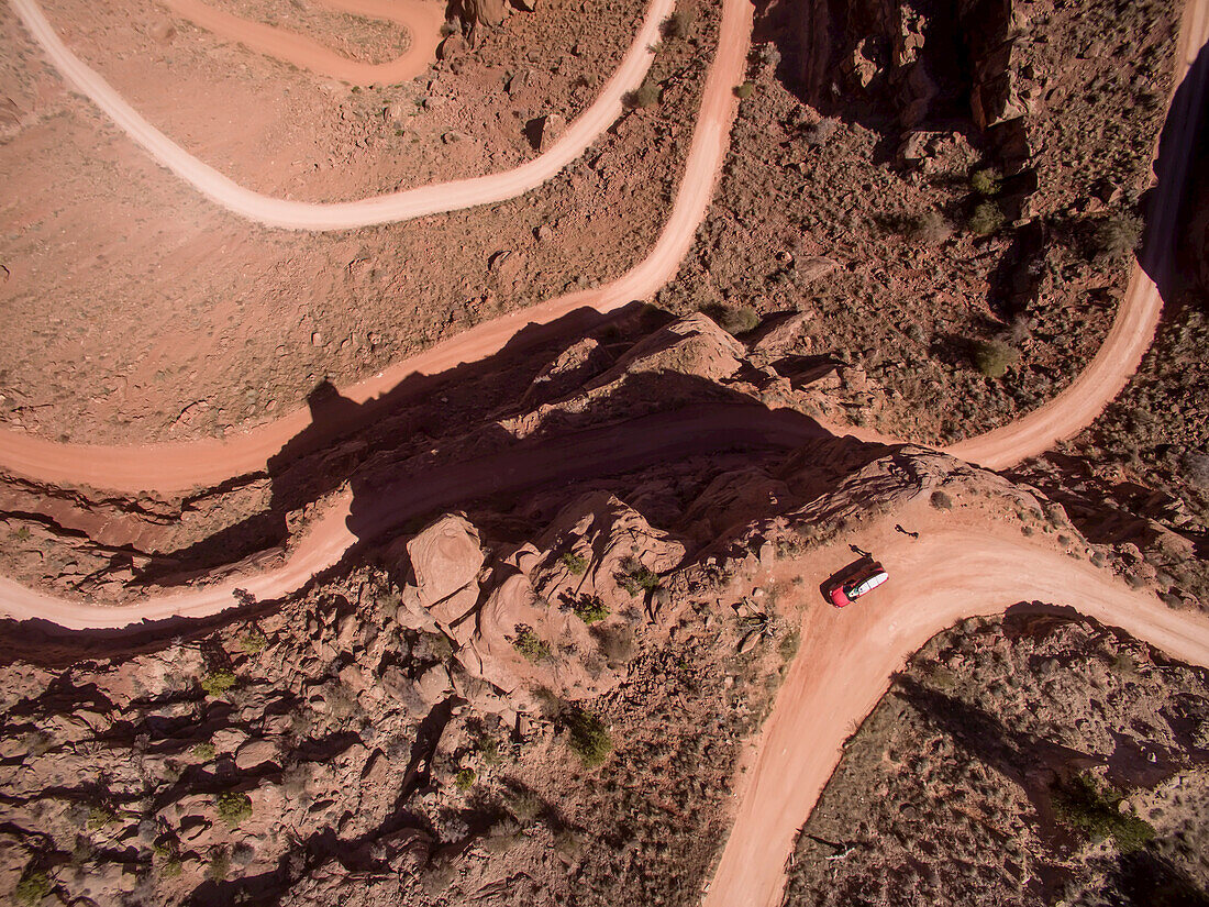 Luftaufnahme einer steilen, kurvenreichen Schotterstraße in Moab, Utah.