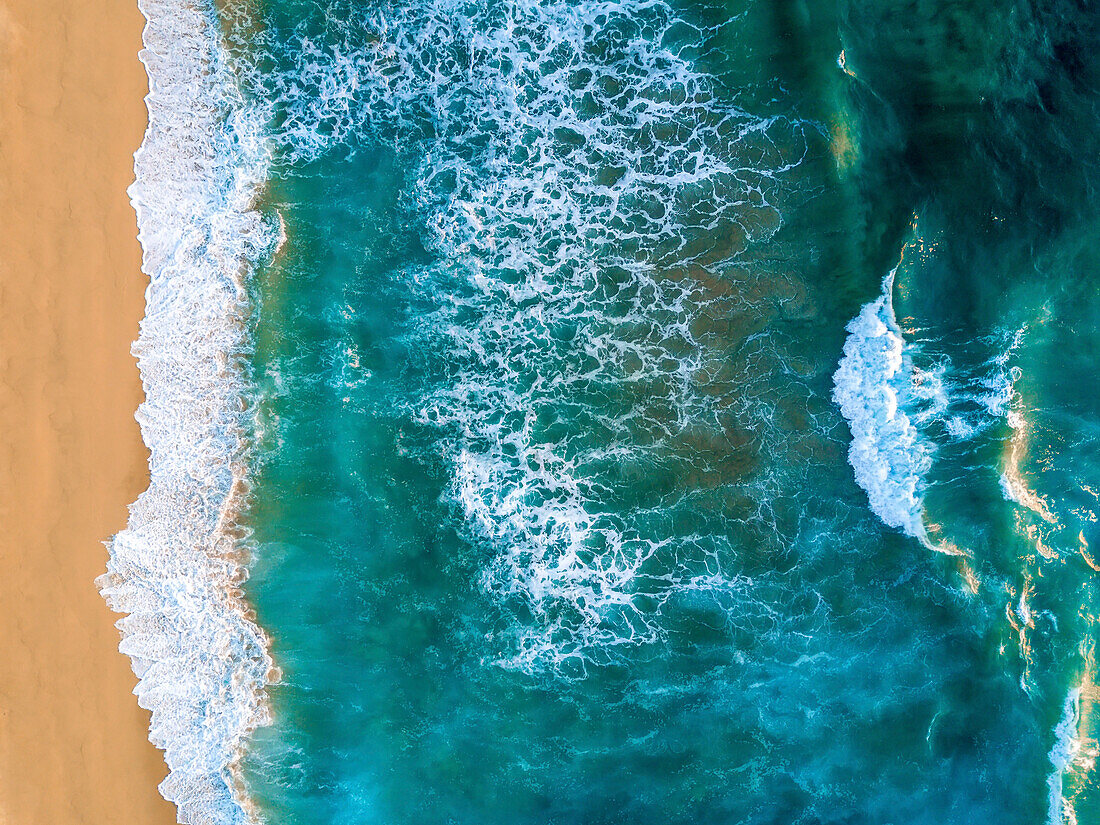 An aerial view of waves crashing against the Baja coastline.
