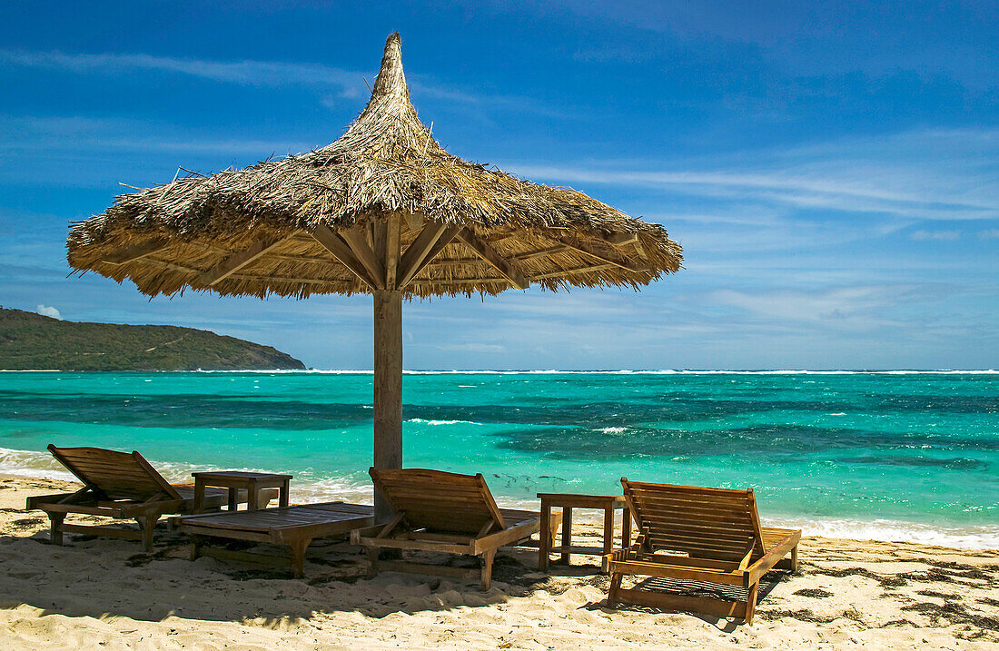 A tropical beach scene in the Caribbean.; Canouan Island, the Grenadines, St Vincent and the Grenadines, in the Caribbean.