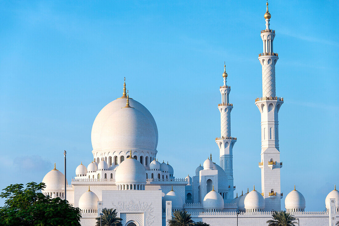 An exterior view of the minarets and domes at the Grand Mosque in Abu Dhabi, UAE, in late afternoon; Abu Dhabi, United Arab Emirates