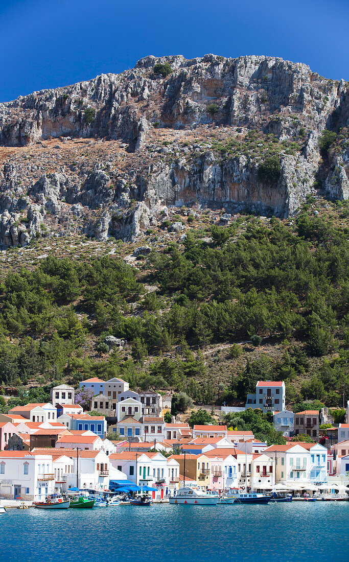 Traditional buildings and boats moored along the shore of the Kastellorizo Harbor on the historical island of Kastellorizo (Megisti) Island; Dodecanese Island Group, Greece