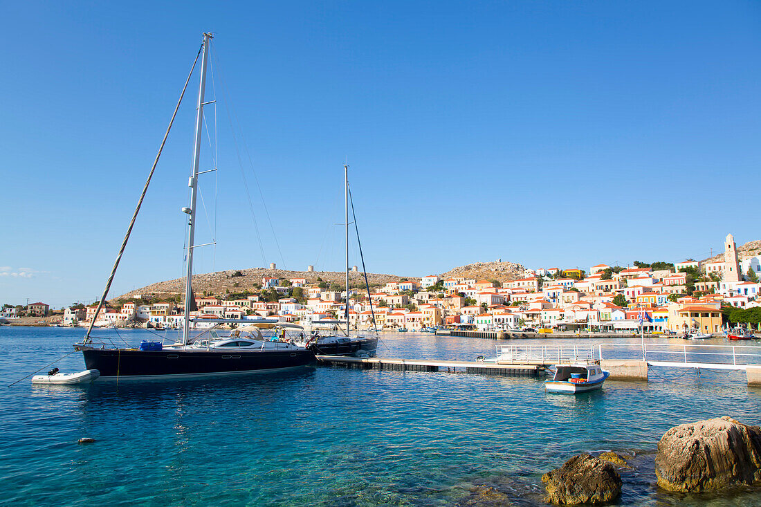 Yachts moored at the dock along the waterfront in the harbor at Emborio, the main town on Halki (Chalki) Island; Dodecanese Island Group, Greece