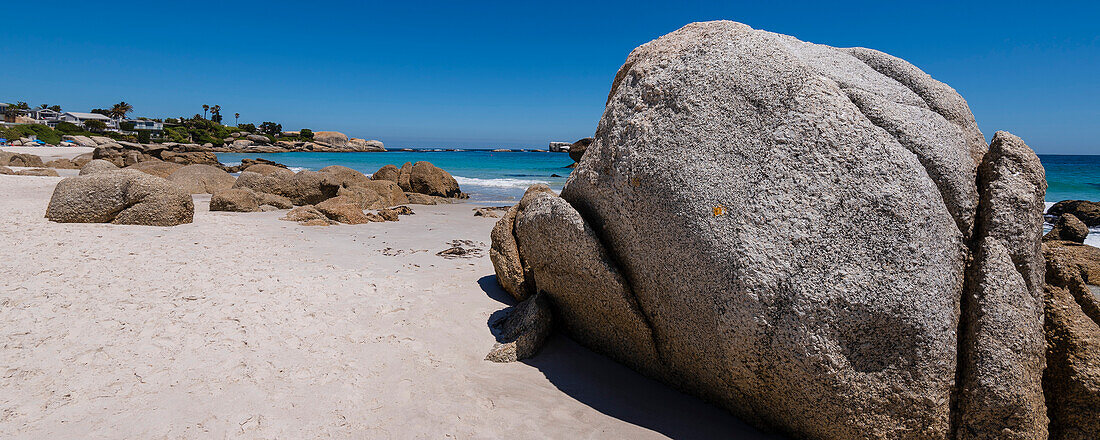 Strandhäuser und große Felsbrocken entlang des Atlantischen Ozeans am Clifton Beach; Kapstadt, Westkap, Südafrika