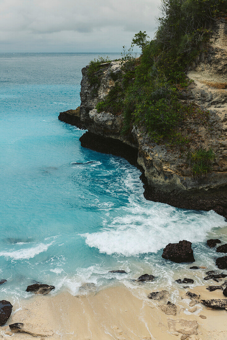 The rocky coast and beachfront of the resort town of Lembongan at the edge of the turquoise waters off the coast of Bali; Nusa Islands, Klungkung Regency, Indonesia