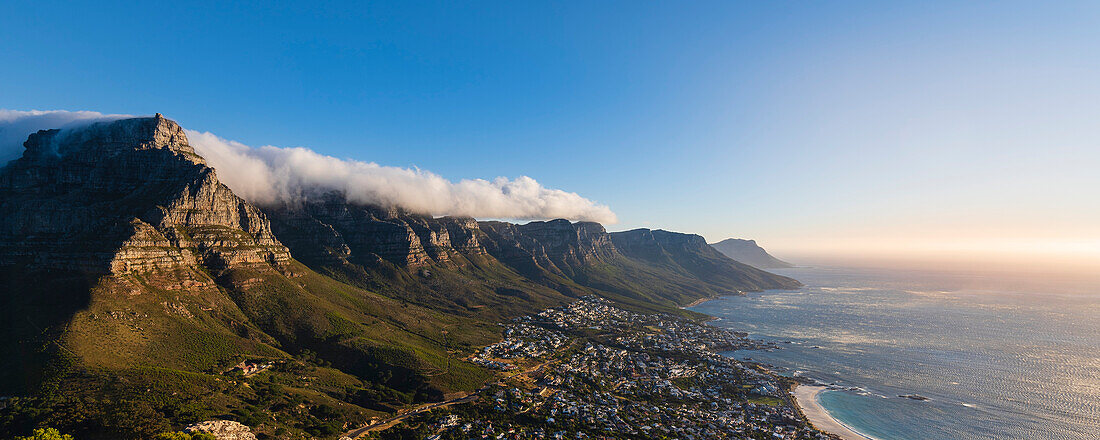 Wolkenformation mit Tischtuch-Effekt über der Zwölf-Apostel-Bergkette mit Blick auf die Skyline von Kapstadt und die Camps Bay an der Atlantikküste; Kapstadt, Westkap-Provinz, Südafrika