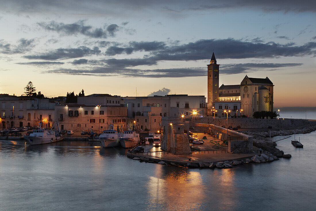 A dusk view of the fishing harbor of Trani.; Trani, Puglia, Italy.