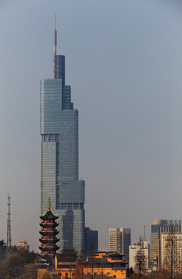 A Ming dynasty pagoda at Jiming Temple, with the modern city behind, Nanjing, Jiangsu province, China.; Jiming Temple, Nanjing, Jiangsu province, China.