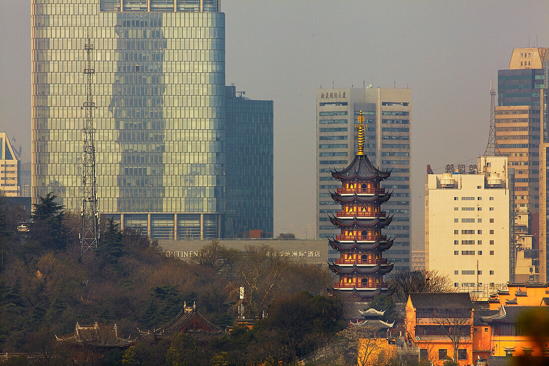 A Ming dynasty pagoda at Jiming Temple, with the modern city behind, Nanjing, Jiangsu province, China.; Jiming Temple, Nanjing, Jiangsu province, China.