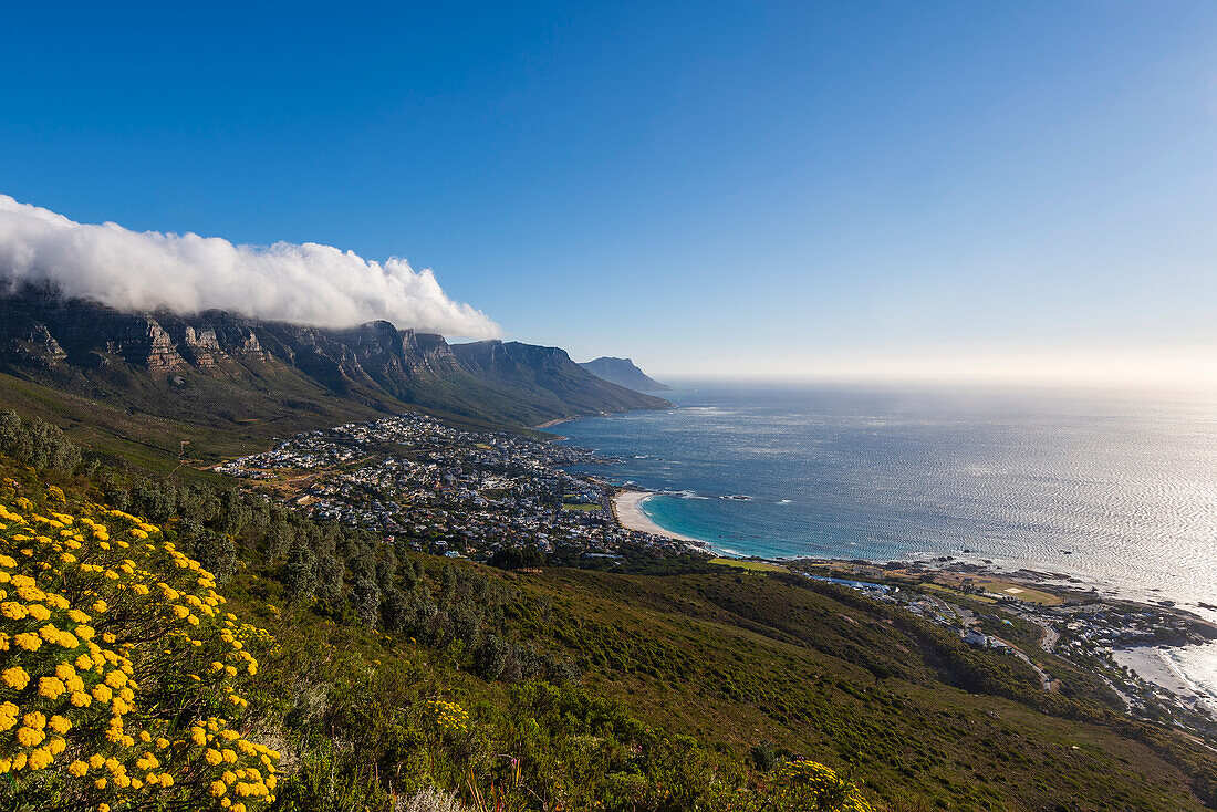 Cloud formation creating table cloth effect over the Twelve Apostles mountain range with an overview of Cape Town city skyline and view of Camps Bay along the Atlantic Ocean Coast; Cape Town, Western Cape Province, South Africa
