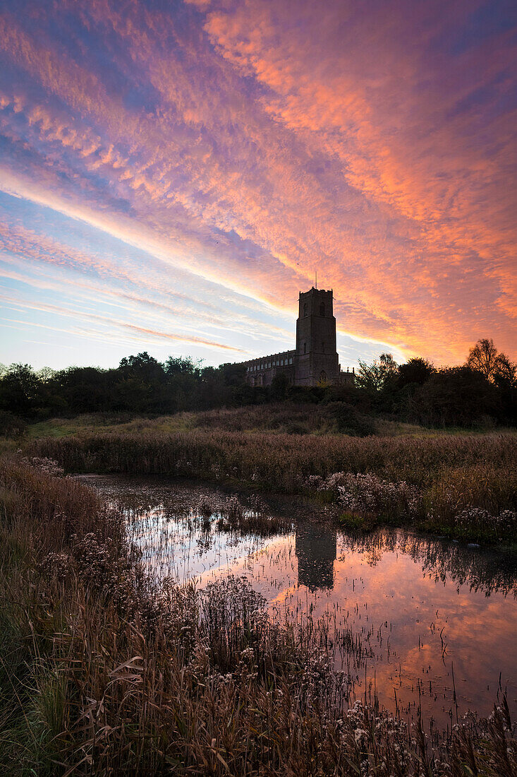 Looking over marshes at dawn to Blythburgh Church; Suffolk, England