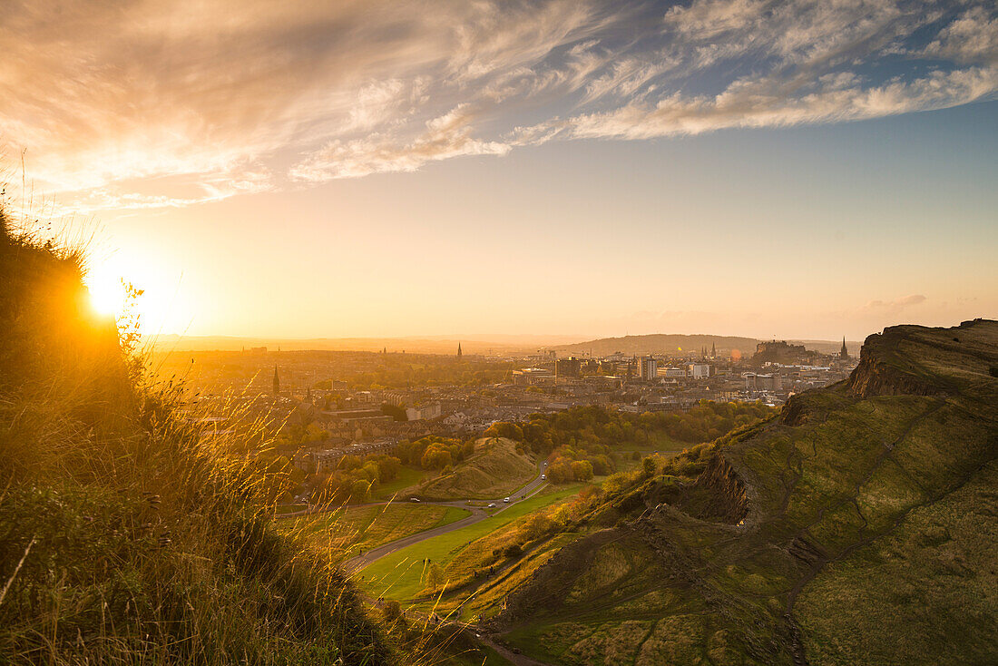 Looking across from Arthur's Seat to Edinburgh Castle and city in the distance at dusk; Edinburgh, Scotland, United Kingdom