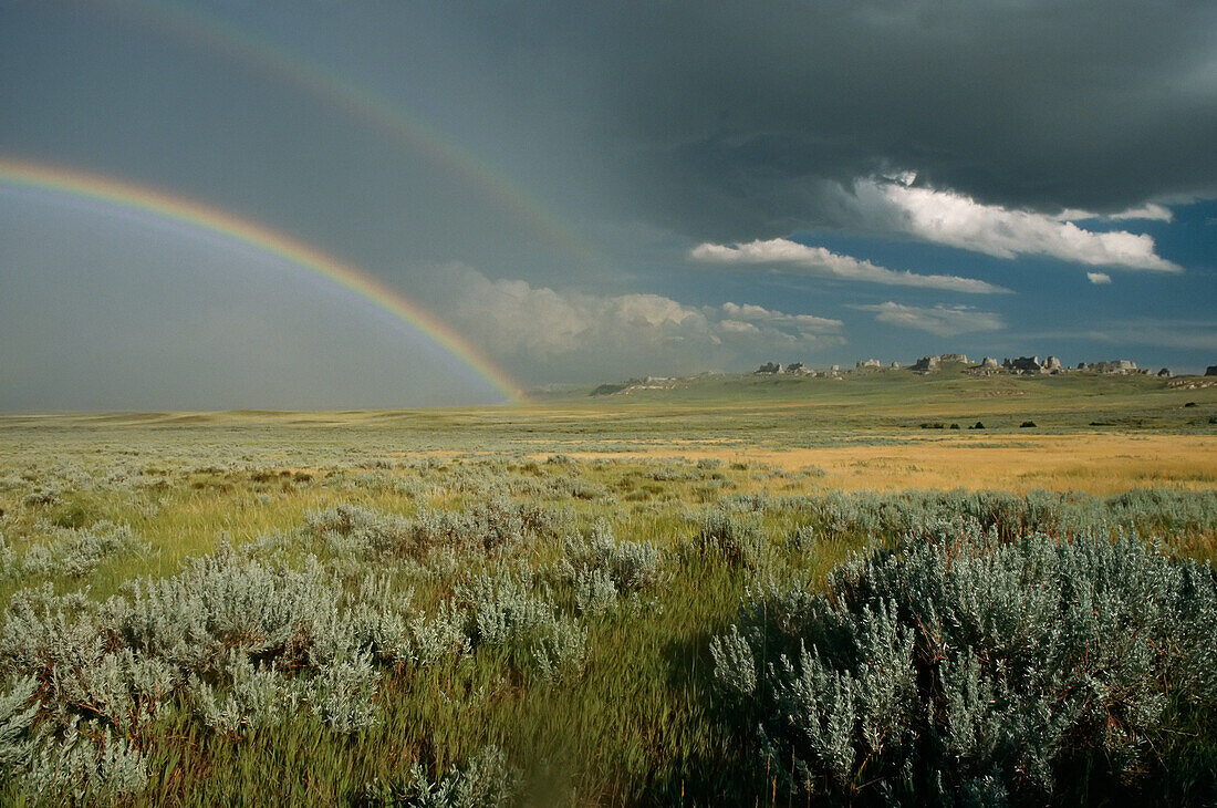 A double rainbow appears above sagebrush in Wyoming.; Wyoming, USA.