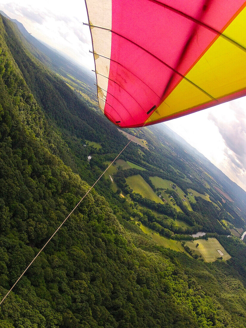 A paraglider soars over the countryside.; Massanutten Mountain, Shenandoah Valley, Virginia, United States.
