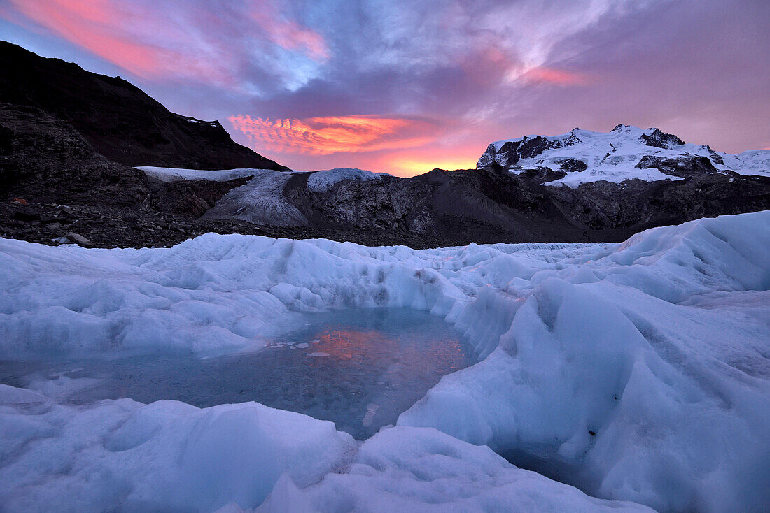 Frozen pool of water on the ice of the Gorner Glacier at sunrise.; Gornergrat, Zermatt, Switzerland.