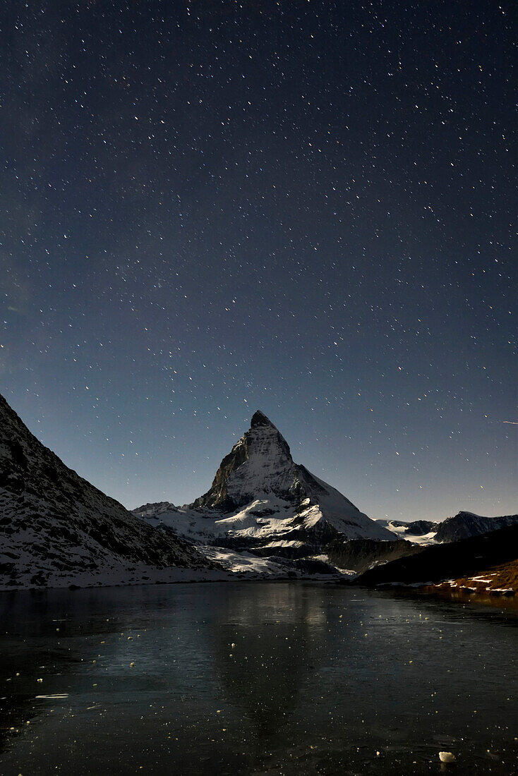 The Matterhorn looms above a frozen lake.; Gornergrat, Zermatt, Switzerland.