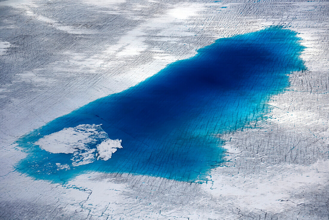 A large pool of water remains on the surface of an ice cap.; Greenland.