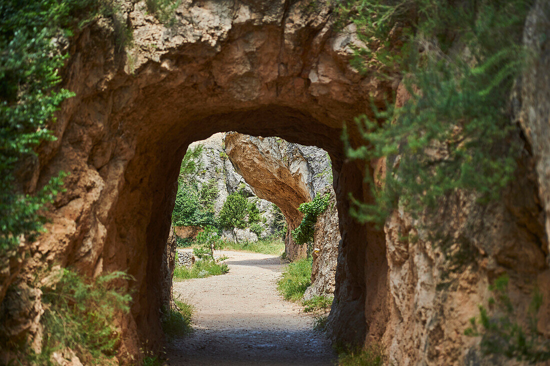 Blick durch den Torbogen eines Felstunnels auf dem Weg nach El Parrizal Beceite und dem Fluss Matarranya in der Provinz Teruel, Autonome Region Aragonien; Spanien