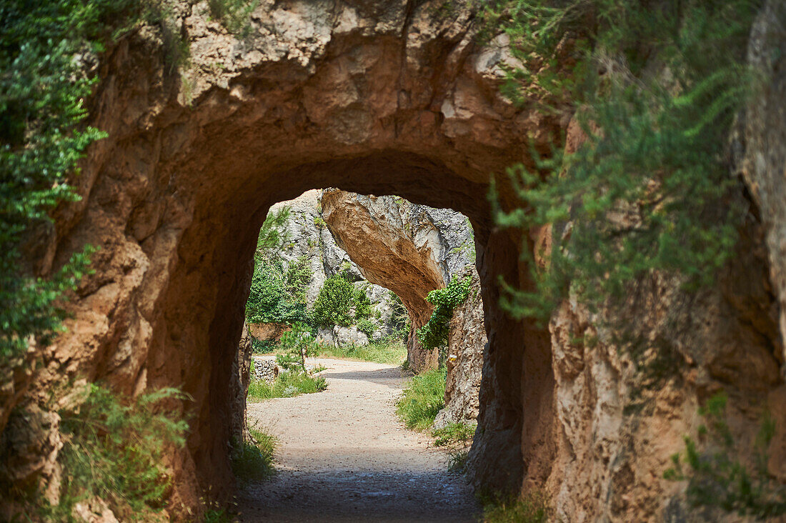 View through archway of a rock tunnel on the route to El Parrizal Beceite and the Matarranya River in the Province of Teruel, Autonomous Region of Aragon; Spain