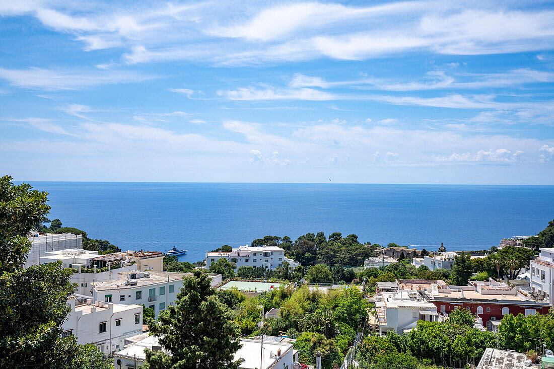 Whitewashed buildings in Capri Town on a plateau like a saddle high above the sea with the island's port, Marina Grande below; Naples, Capri, Italy