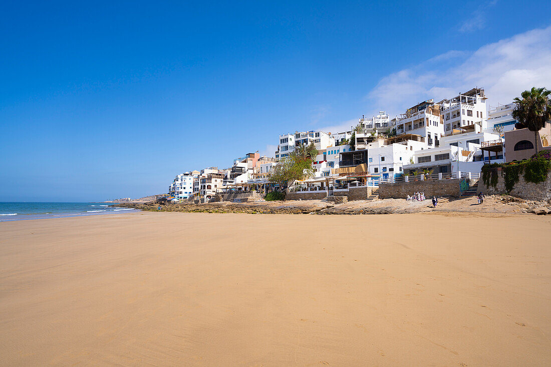 Apartments and restaurants on the hillside along Taghazout Village beach; Taghazout Bay, Agadir, Morocco