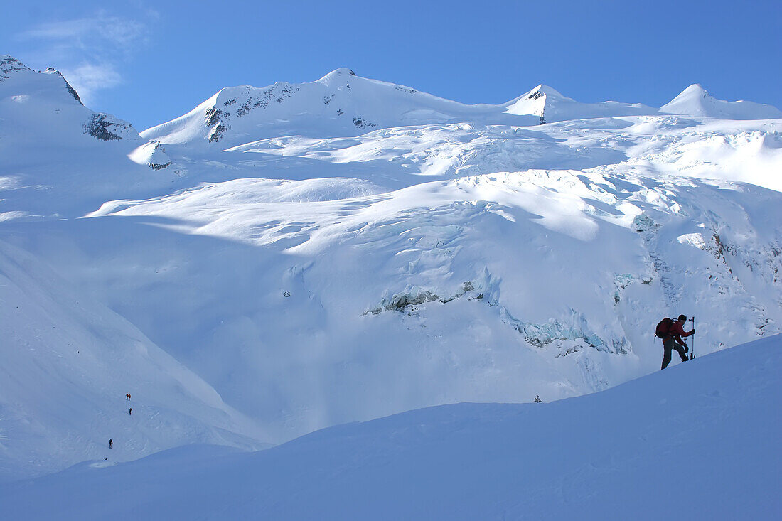 A back country snowboarder and a glacier.; Selkirk Mountains, British Columbia, Canada.