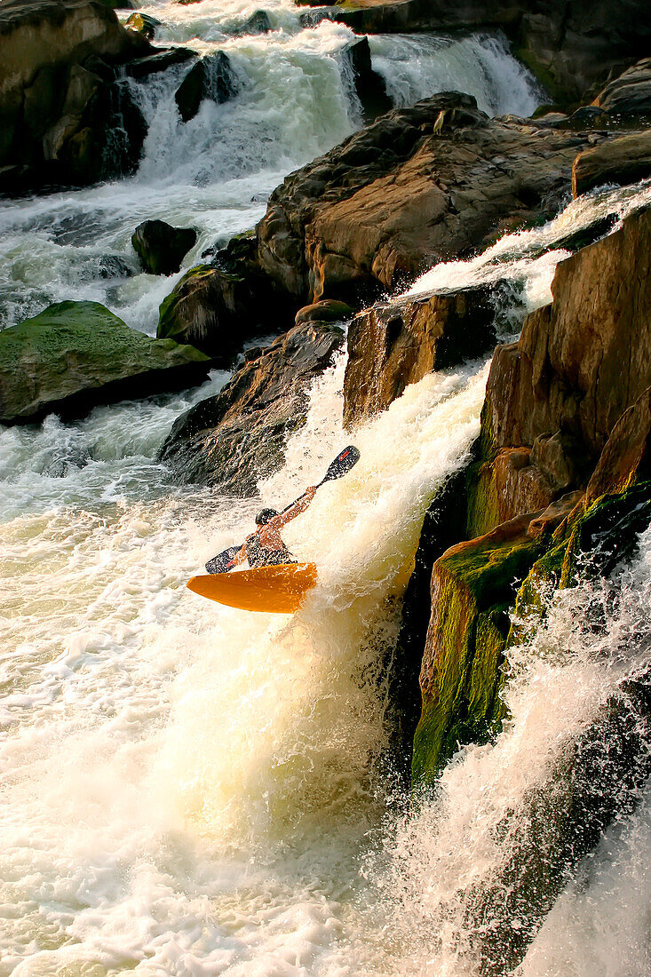 Ein Kajakfahrer, der sich über einen großen Wasserfall schwingt; Great Falls, Potomac River, Maryland.