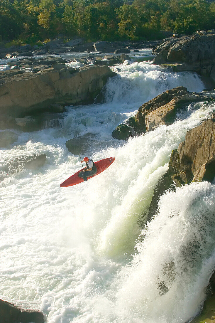 A whitewater kayaker drops off a waterfall at Great Falls.; Great Falls, Potomac River, Maryland.