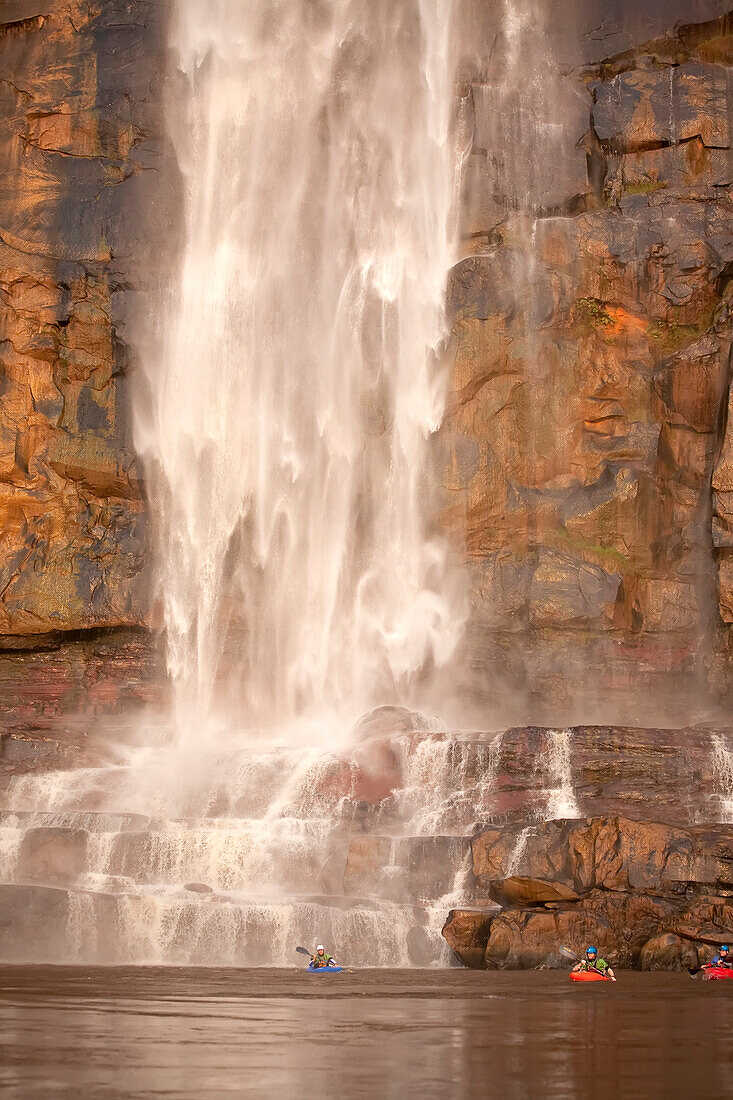 Kayakers at the base of a large waterfall.; Congo River, Democratic Republic of the Congo.