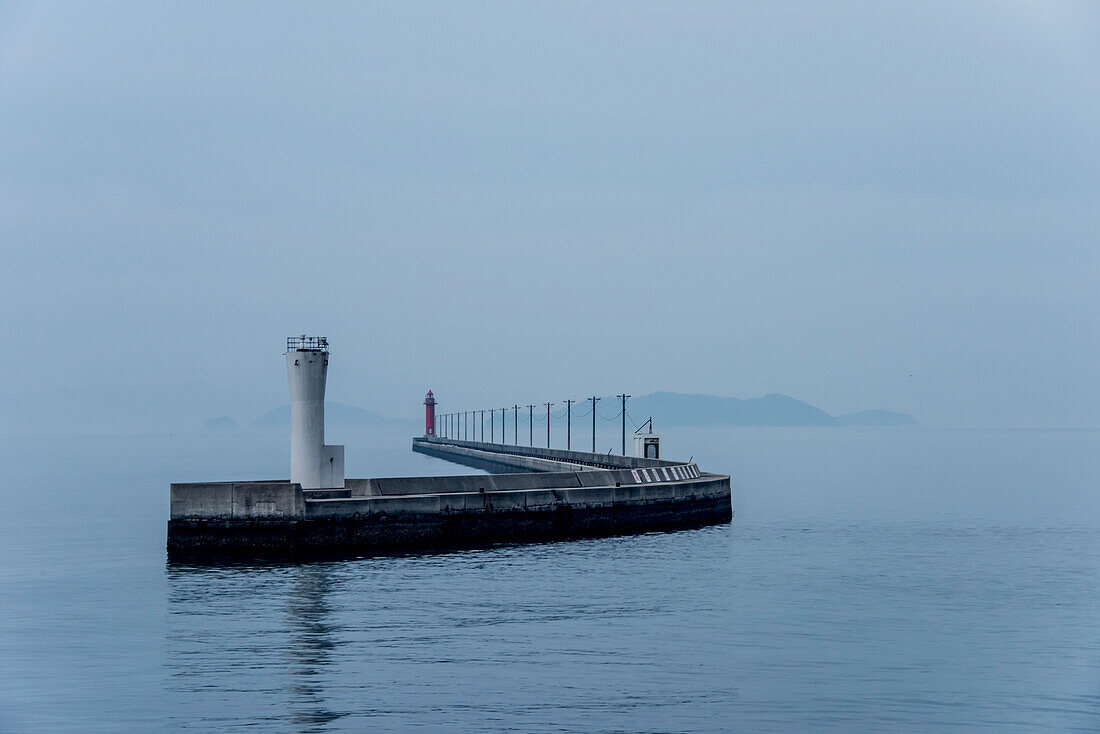 Wellenbrecher und Leuchtturm im Hafen von Naoshima, einer Inselstadt in Japans Seto-Binnenmeer; Shikoku, Japan