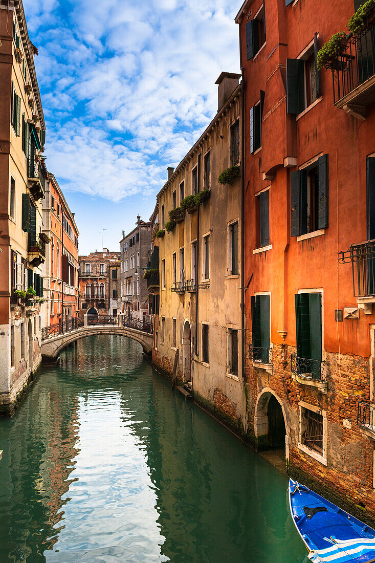 Typical stone buildings and view through a canal with a footbridge in Veneto; Venice Italy