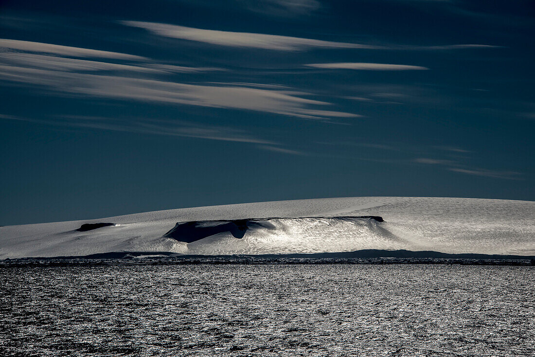 Sun reflecting on ice and snow on a wind-lashed Anderson Island in Antarctic Sound; Antarctica
