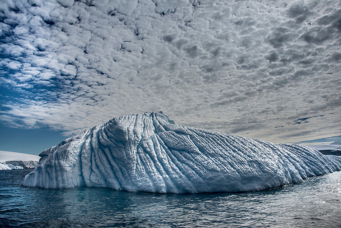Hohe Wolken über einem Eisberg vor der Enterprise-Insel in der Antarktis; Antarktis