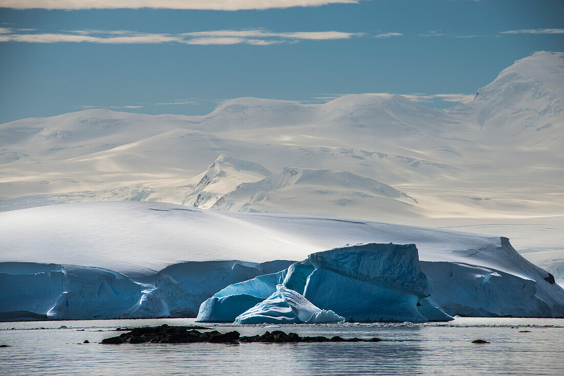 Schneebedeckte Berge erheben sich über einem Eisberg vor der Enterprise-Insel in der Antarktis; Antarktis