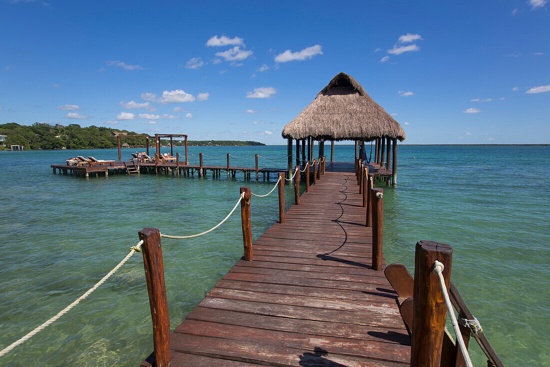 Tiki-Hütten-Pavillon auf dem Steg mit türkisfarbenem Wasser im Rancho Encantado Eco-Resort & Spa in Bacalar; Quintana Roo, Mexiko
