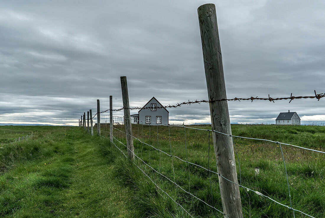 Farm buildings and wire and post fence on a farm on Flatey Island, part of a cluster of about forty large and small islands and islets located in Breiðafjörður on the northwestern part of Iceland; Western Islands, Iceland