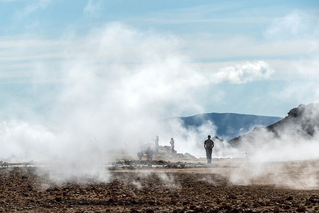 Menschen stehen am Aussichtspunkt und fotografieren den Myvatn-See, umgeben von dem Dampf, der aus den geothermischen Schloten aufsteigt. Das Myvatn-Seegebiet ist eine der geologisch aktivsten Regionen Islands; Myvatn-See, Nordisland, Island